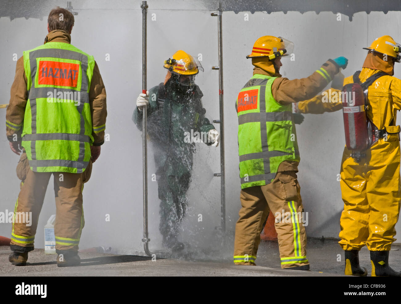 Servizio antincendio lavi giù sulla scena di un materiali pericolosi incidente Foto Stock