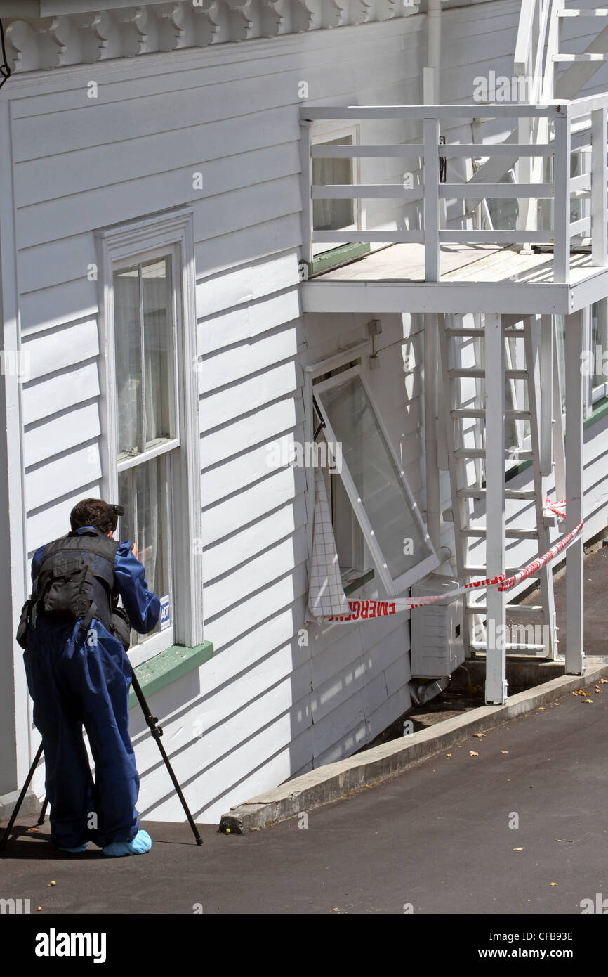 Un fotografo della polizia sulla scena di un assalto ad un residente di sesso maschile, Eden Park Lodge, Dominion Road, Auckland, Nuova Zelanda Foto Stock