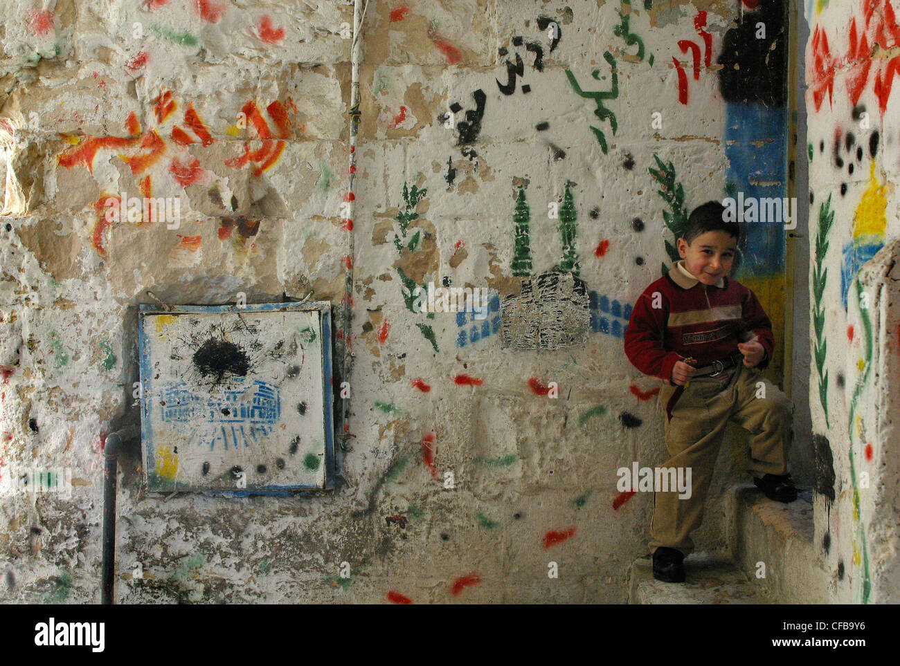 Ragazzo sui gradini davanti ad una pittura murale raffigurante il Hajj, nella città vecchia di Gerusalemme . Foto Stock