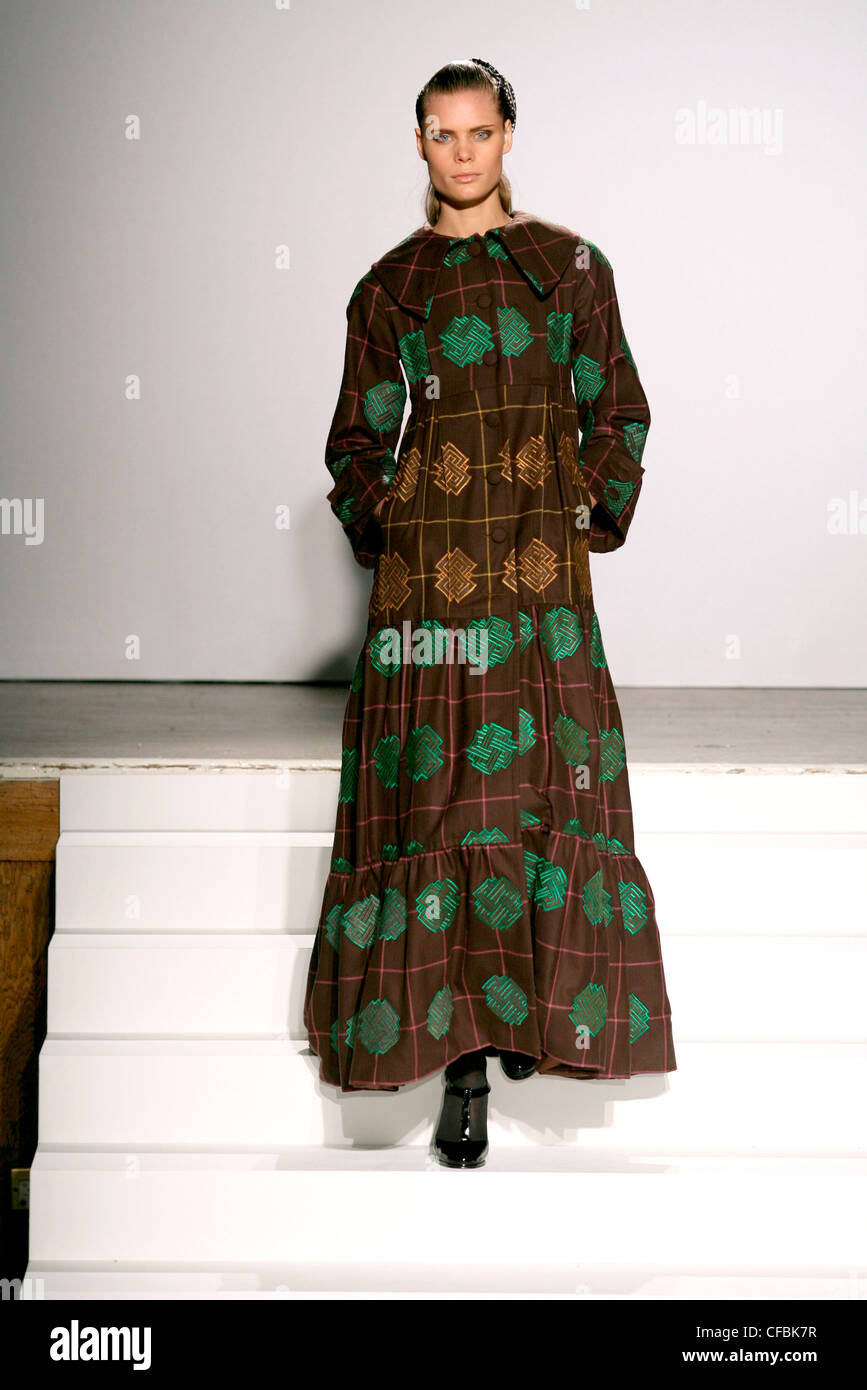 Duro Olowu Londra pronto a indossare in autunno e inverno modello Adina Fohlin indossando lunghezza alla caviglia cappotto marrone verde smeraldo e bronzo Foto Stock
