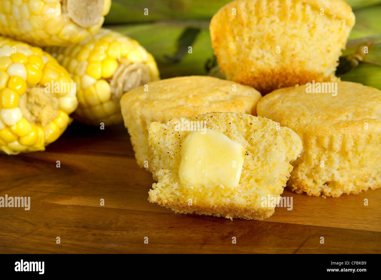 Tagliare muffin di mais con una pacca di burro e ingredienti Foto Stock