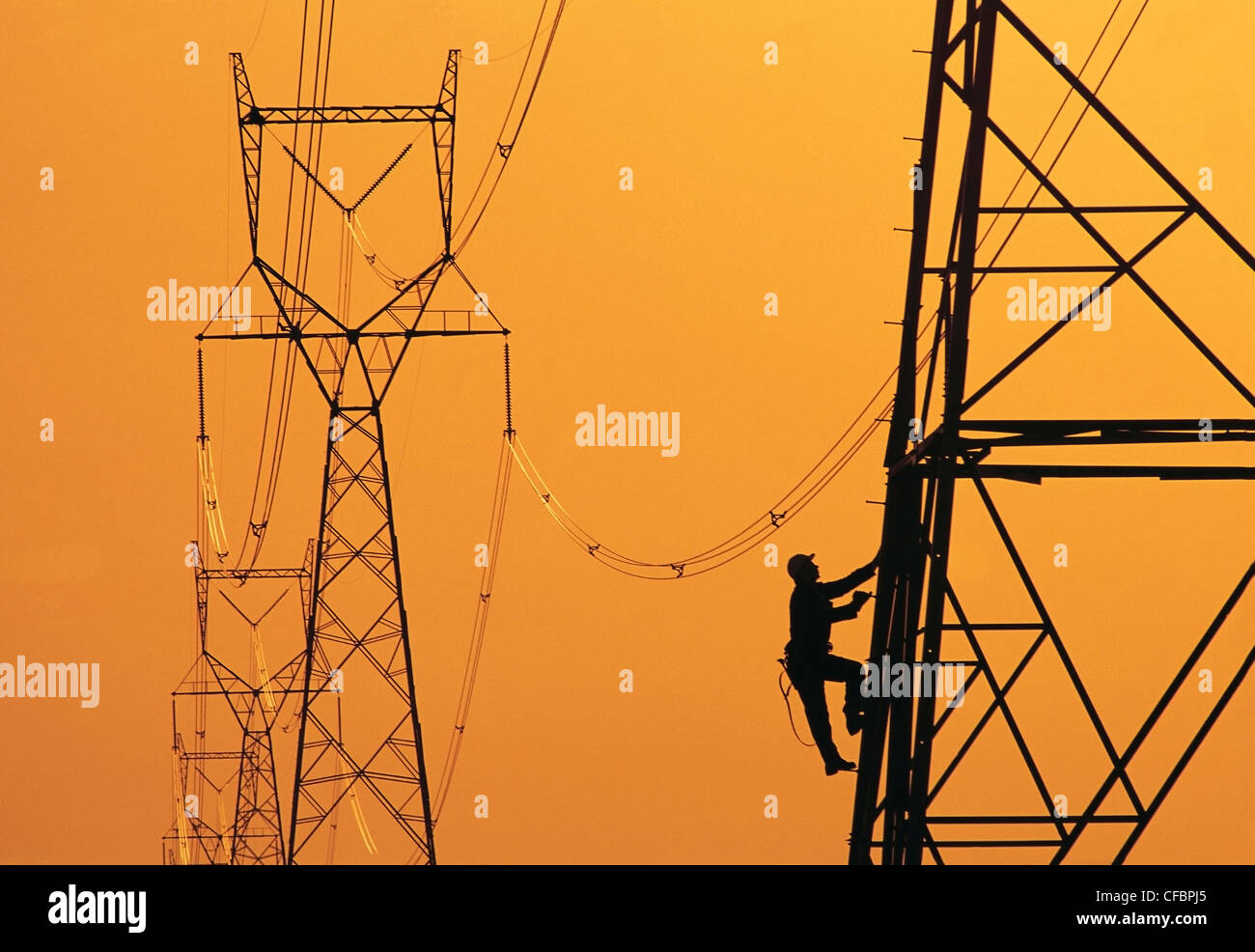 Un operaio si arrampica su una torre elettrica, Manitoba, Canada Foto Stock