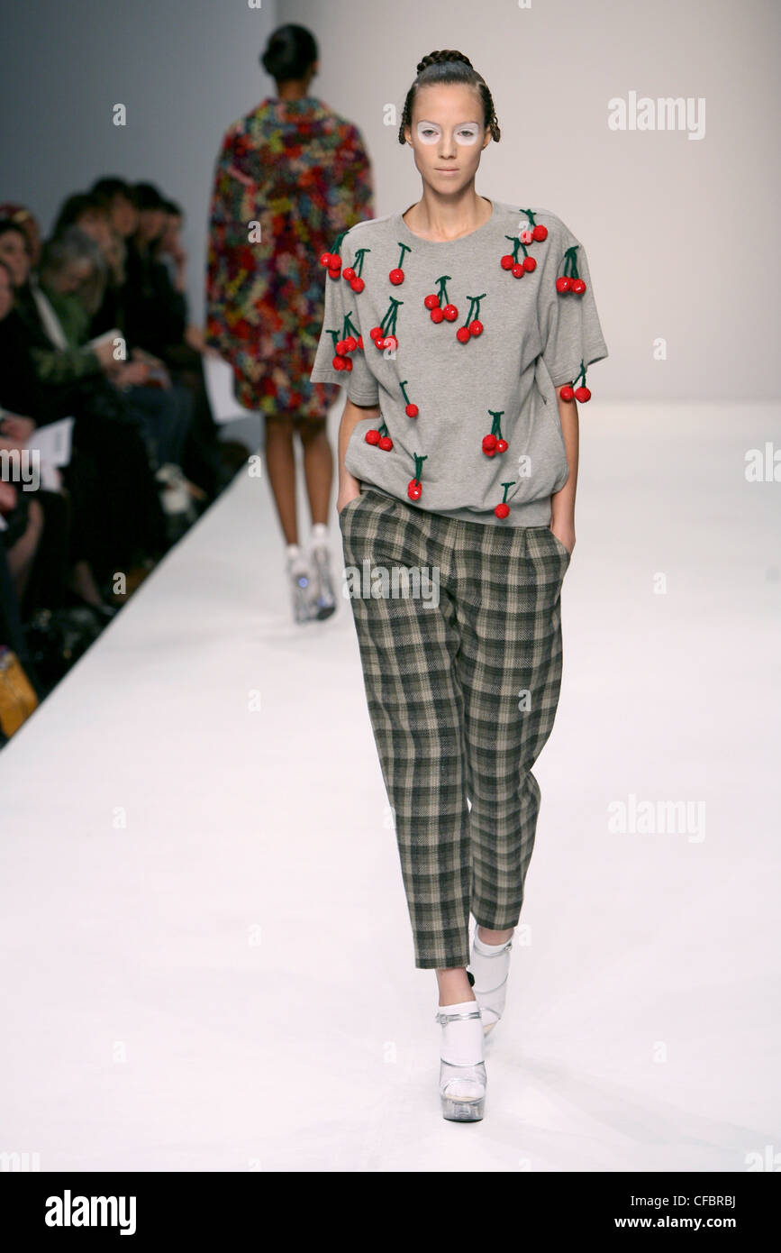 Ashish Londra pronto a indossare in autunno e inverno di controllo grigia  pantaloni ritagliata, grigio t shirt ciliege rosse, scarpe chiare su calze  bianche Foto stock - Alamy