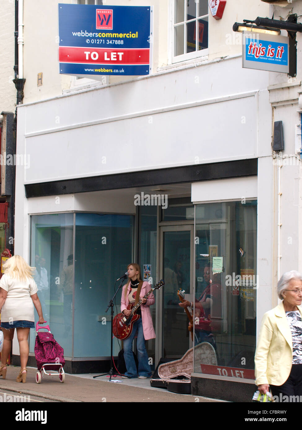 Busker all ingresso del negozio vuoto, Barnstaple, Devon, Regno Unito Foto Stock