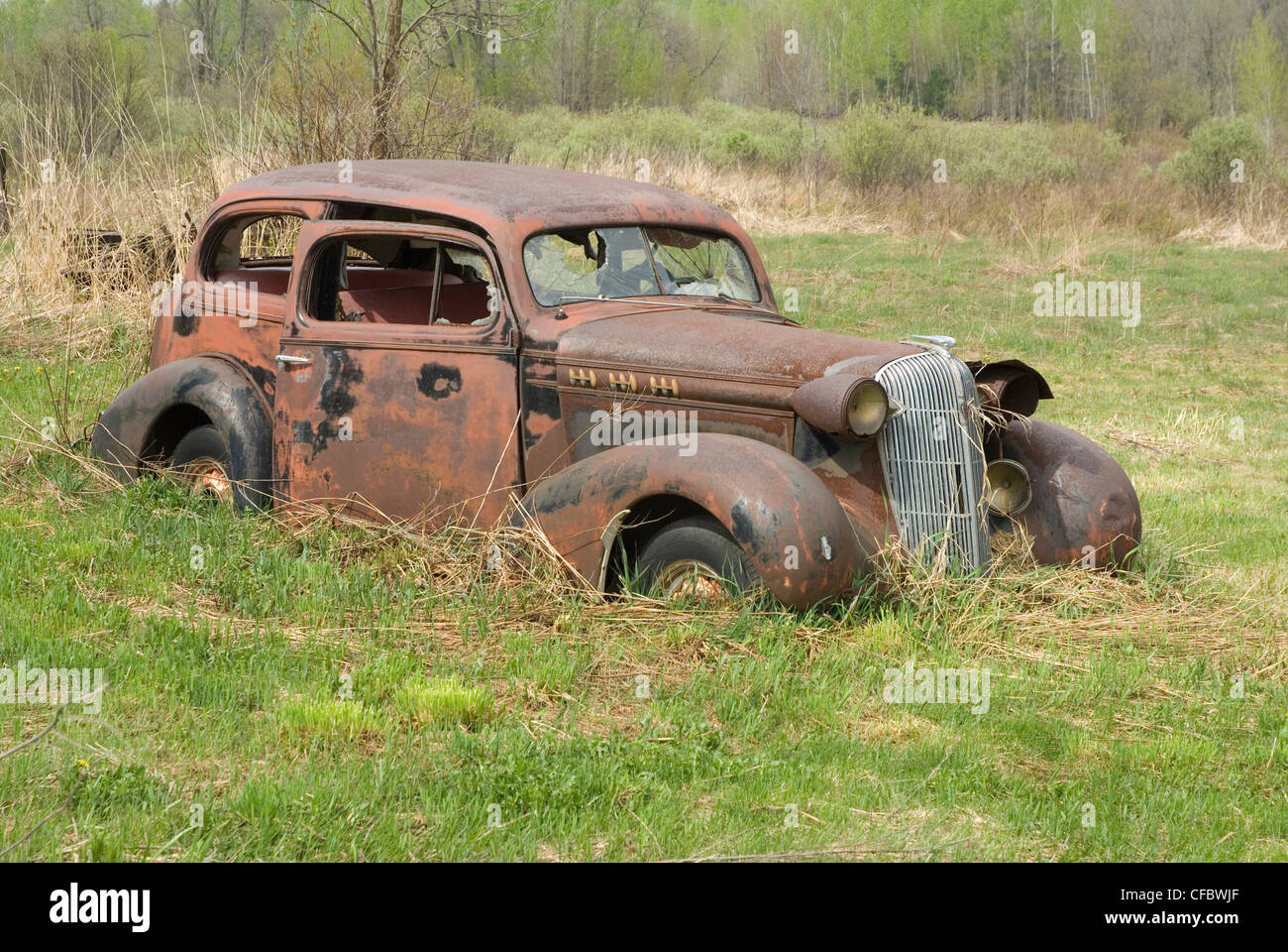 Rusty vecchia auto seduto in un campo in Ramara Township, Ontario, Canada. Foto Stock