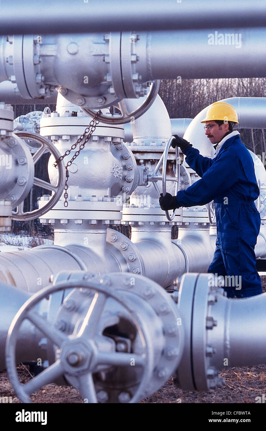 Industria petrolifera lavoratore ruotando la valvola sulla pipeline Foto Stock