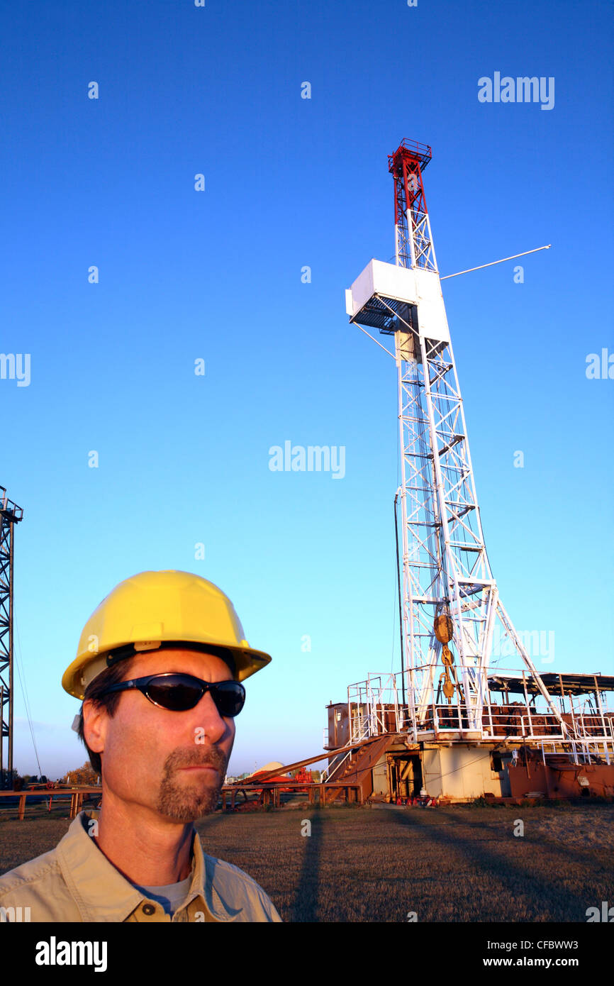 Oil Rig Lavoratore che indossa il disco duro a impianto di perforazione in Alberta, Canada Foto Stock