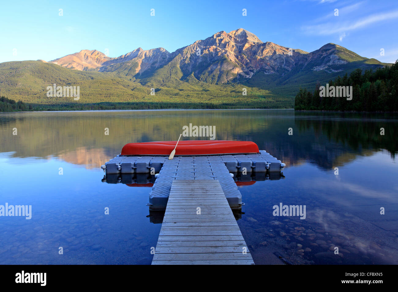 Red canoa sul dock a Lago Piramide con la piramide, di montagna del Parco Nazionale di Jasper, Alberta, Canada. Foto Stock