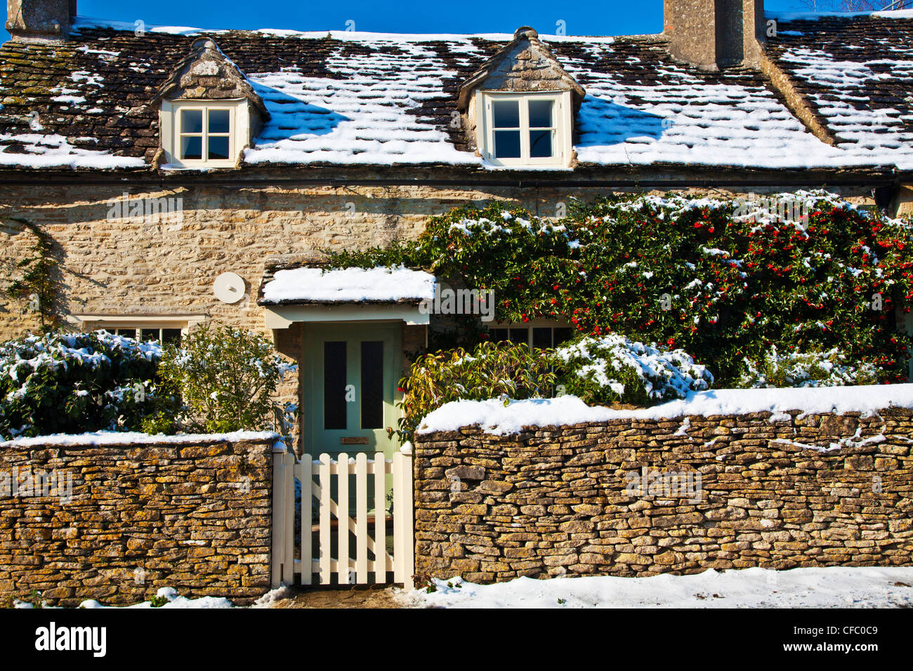 Un grazioso Cotswold cottage in pietra nella neve a Ampney San Pietro, Gloucestershire, England, Regno Unito Foto Stock
