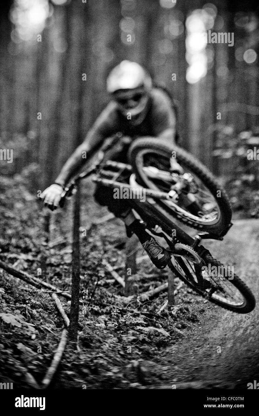 Giovane maschio mountain biker cattura aria sulla montagna di alci, Kananaskis AB Foto Stock