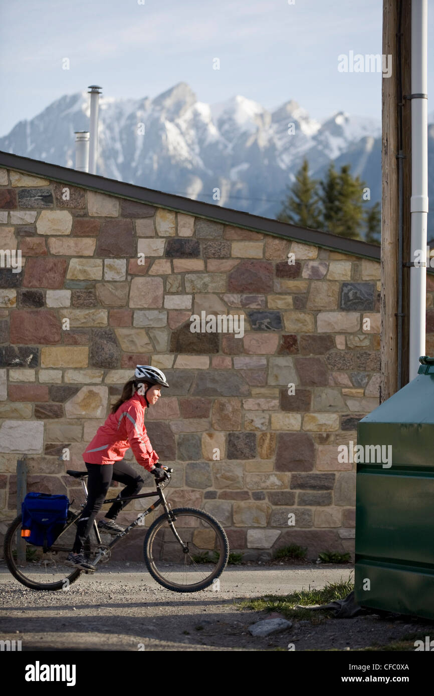 Una giovane donna il pendolarismo sulla sua bici in Canmore, AB Foto Stock