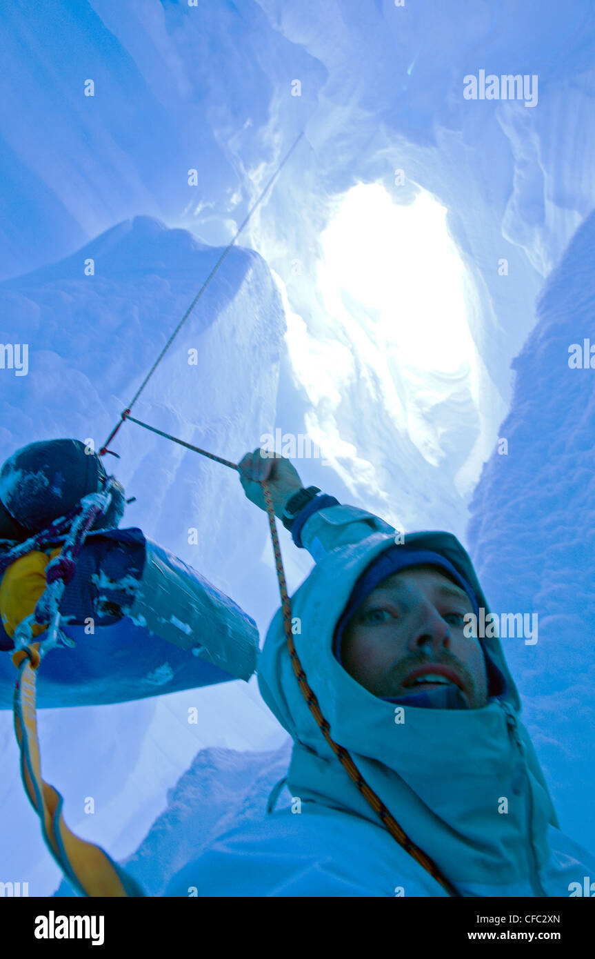 Uno sciatore che è caduto in un crepaccio mentre viaggia su un ghiacciaio nella gamma di Darwin, Cile, si trova in una situazione difficile Foto Stock