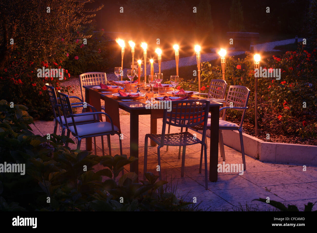 Decorate Tavolo da giardino con torce fiammeggianti nella luce della sera,  Baviera, Germania Foto stock - Alamy