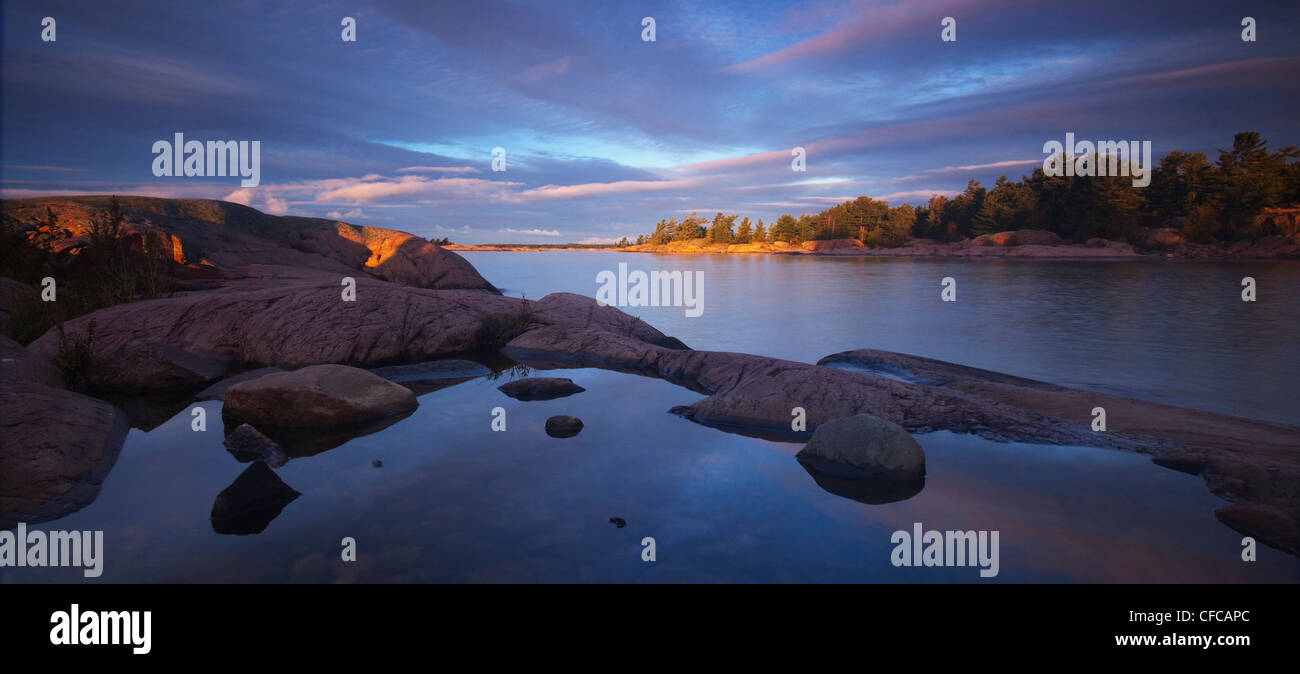 La luce del mattino colpisce le isole di granito in Georgian Bay in Killarney Provincial Park in Ontario del nord. Foto Stock