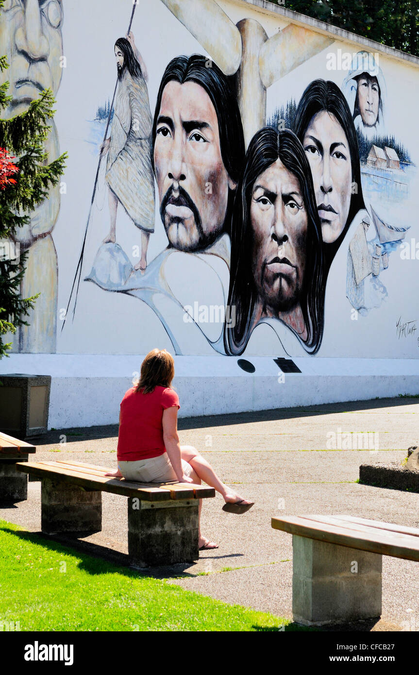 Donna che guarda al murale di prime nazioni nella Chemainus, British Columbia, Canada Foto Stock