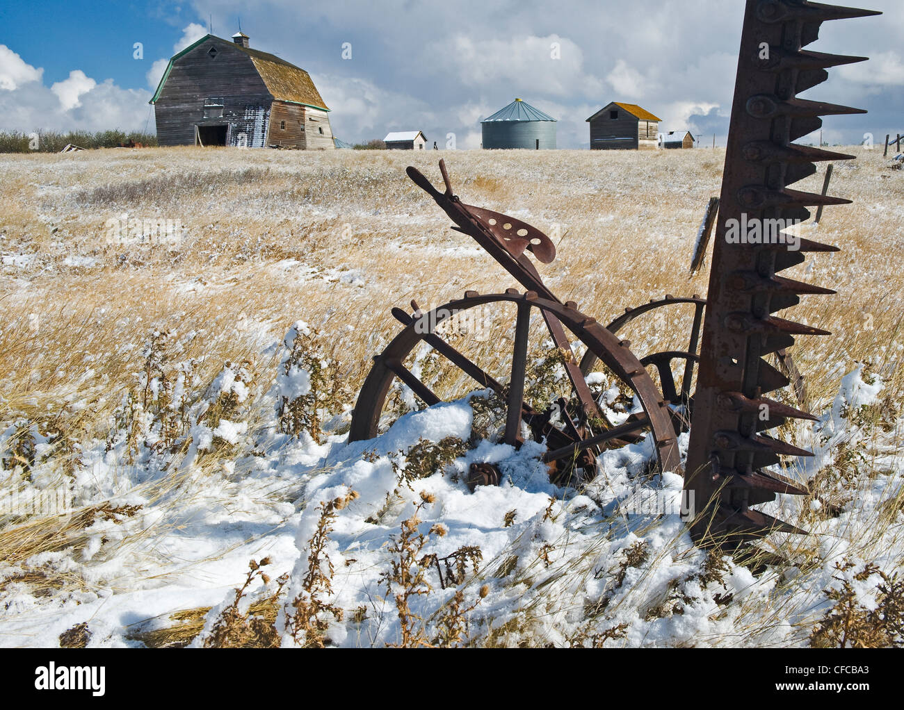 Il vecchio fienile con barra falce tosaerba di fieno in primo piano vicino Hazenmore, Saskatchewan, Canada Foto Stock