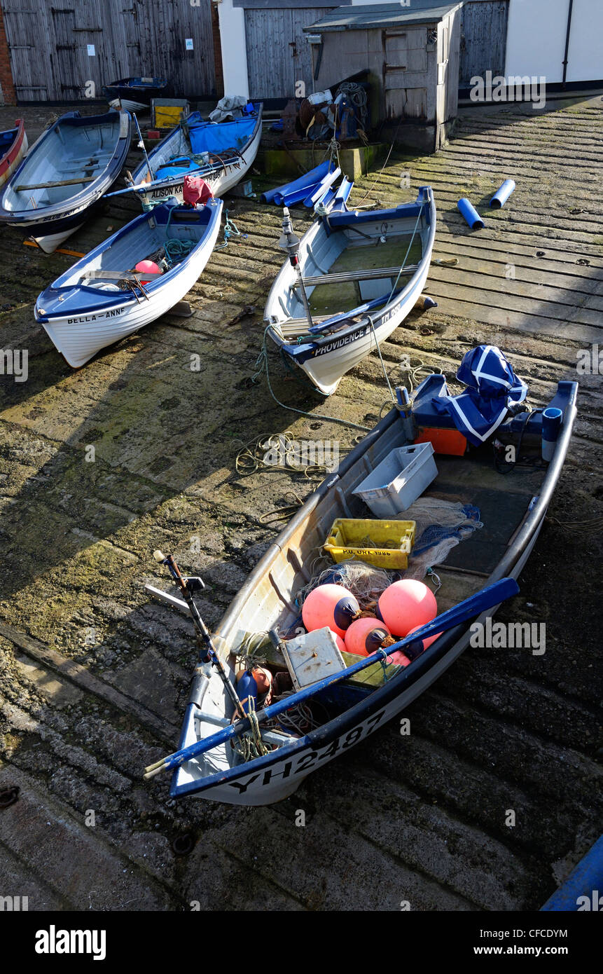 Fascia costiera di granchi e aragoste barche da pesca cazzate fino sul cemento di uno scalo, Sheringham, Norfolk, Regno Unito Foto Stock