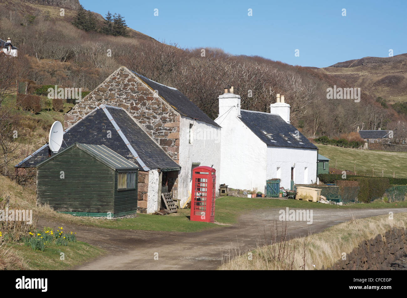 Il Post Office, capanna verde in primo piano e un telefono rosso casella sulla isola di canna. Ebridi Interne, Scozia. Foto Stock