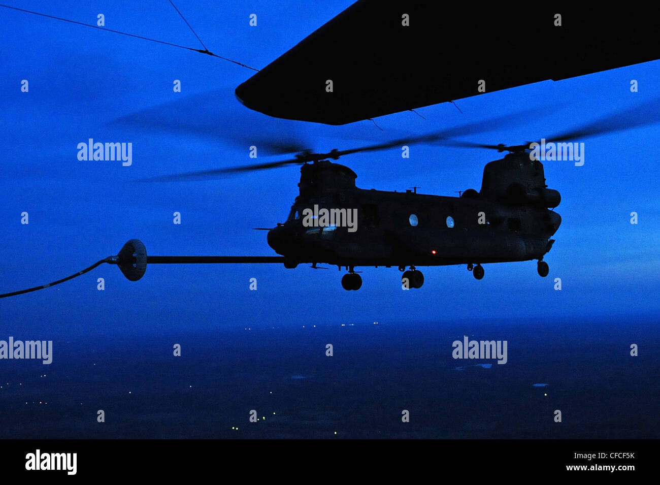 Un elicottero Chinook dell'esercito degli Stati Uniti CH-47 riceve un rifornimento aereo da un aeromobile MC-130E durante Emerald Warrior, Duke Field, Fla., 6 marzo 2012. Lo scopo principale del guerriero Smeraldo è quello di esercitare componenti operativi speciali in ambienti di guerra urbani e irregolari per supportare i comandanti combattenti nelle campagne teatrali. Emerald Warrior sfrutta le lezioni dell'operazione libertà irachena, dell'operazione libertà duratura e di altre lezioni storiche per fornire forze meglio addestrate e pronte ai comandanti combattenti. Foto Stock