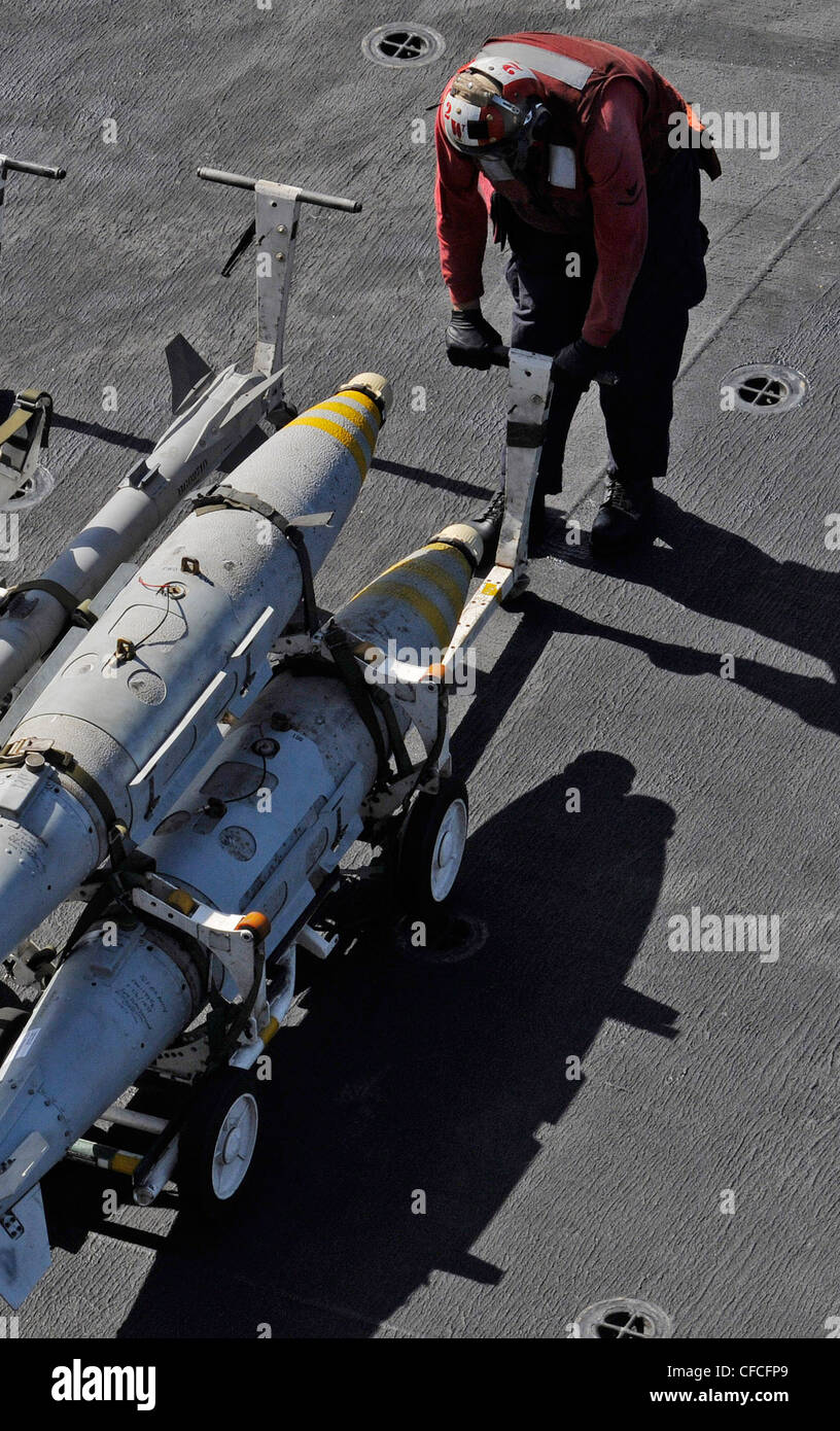 ARABIAN SEA (6 marzo 2012) un ordnanceman dell'aviazione muove ordnance sul ponte di volo della portaerei di classe Nimitz USS Abraham Lincoln (CVN 72). Abraham Lincoln è schierato nella 5 ° flotta degli Stati Uniti di responsabilità che conduce operazioni di sicurezza marittima, gli sforzi di cooperazione di sicurezza del teatro e le missioni di sostegno come parte di operazione Enduring Freedom. Foto Stock