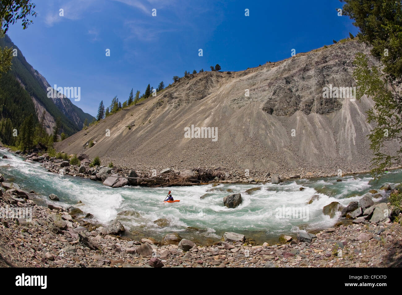 Un maschio di kayaker pagaie il fiume Wigwam, classe 4 in Fernie, British Columbia, Canada Foto Stock