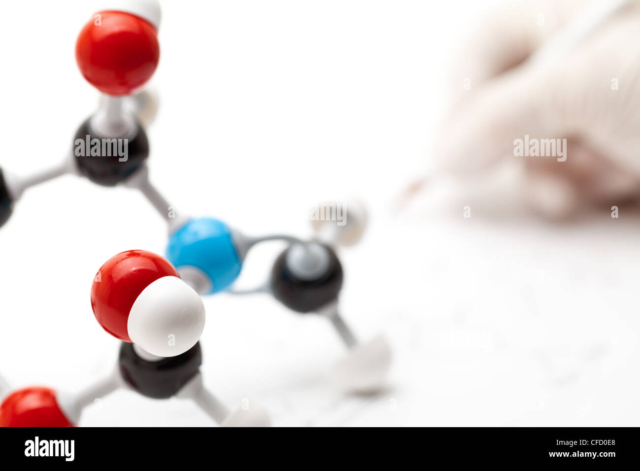 Modello di molecola con il ricercatore a prendere appunti in background Foto Stock