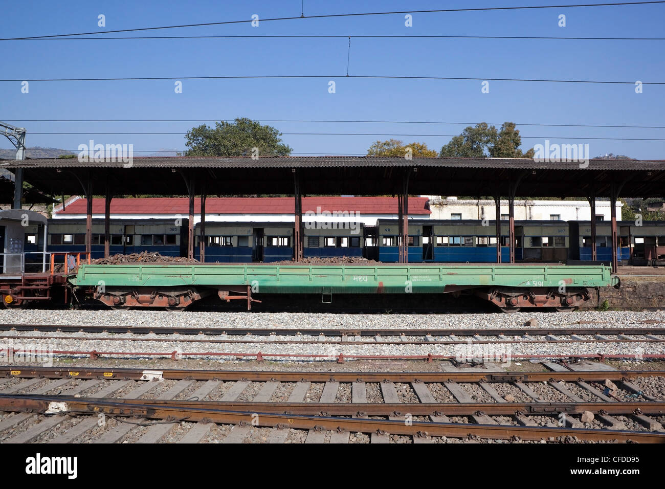 Il materiale rotabile a Kalka stazione ferroviaria accanto a una piattaforma con i binari ferroviari e cavi elettrificata nello Stato di Haryana, India Foto Stock