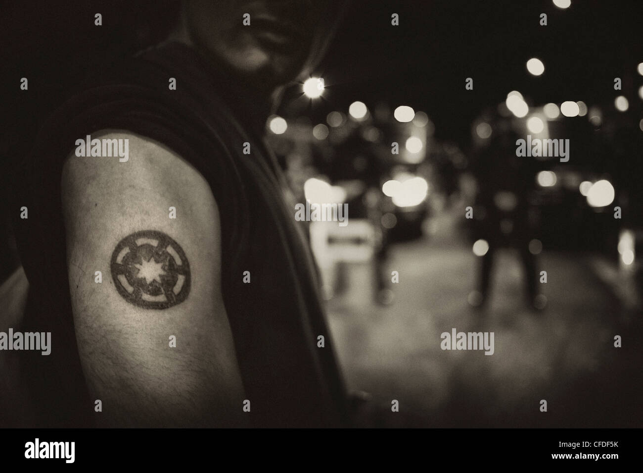 Tatuaggio simbolo del movimento spagnolo di indignarsi sul braccio di un manifestante durante una dimostrazione in Barcellona. Foto Stock