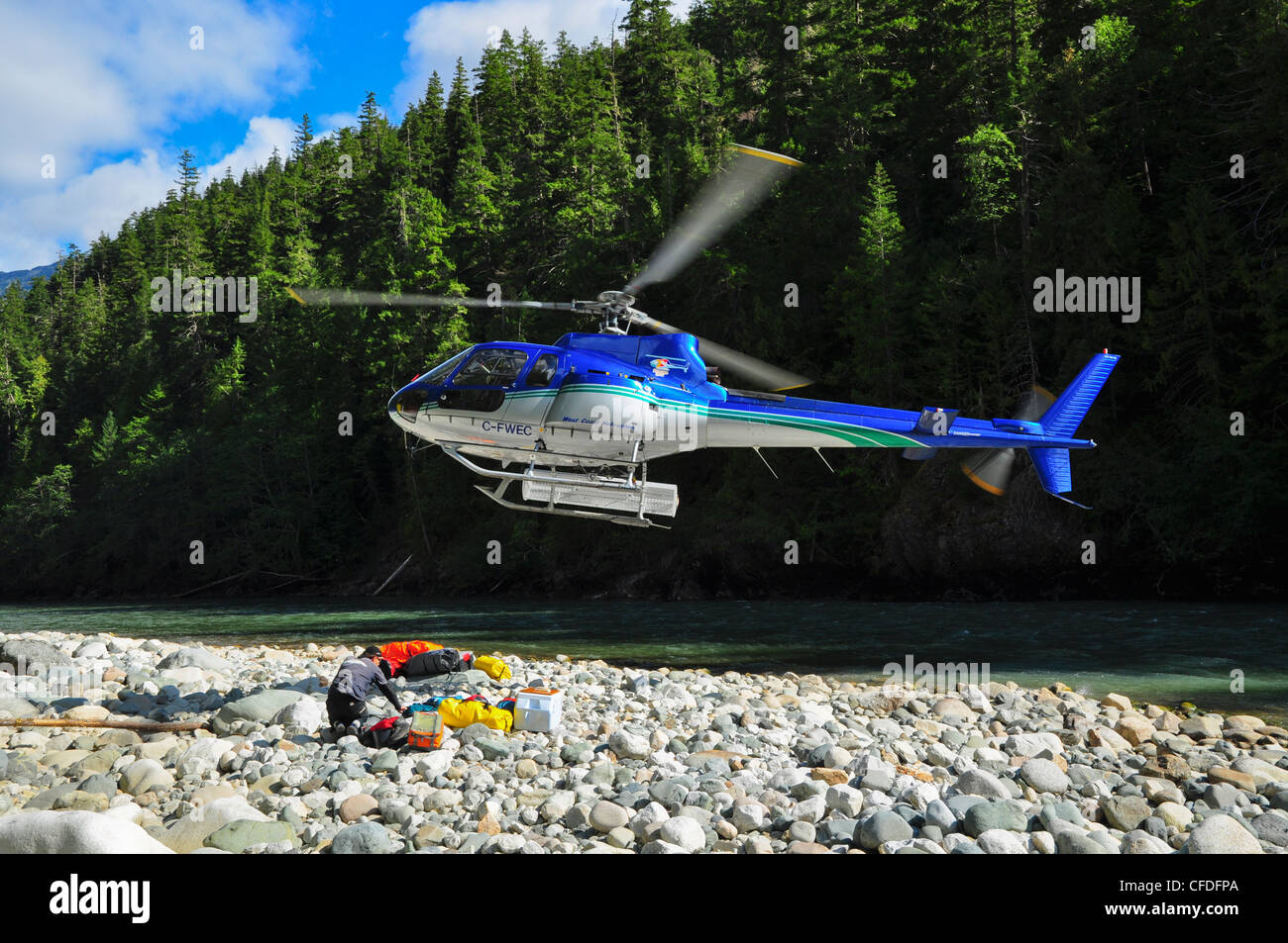 Uomo con ingranaggio e elicottero per la pesca con la mosca viaggio, Dean River, British Columbia, Canada Foto Stock