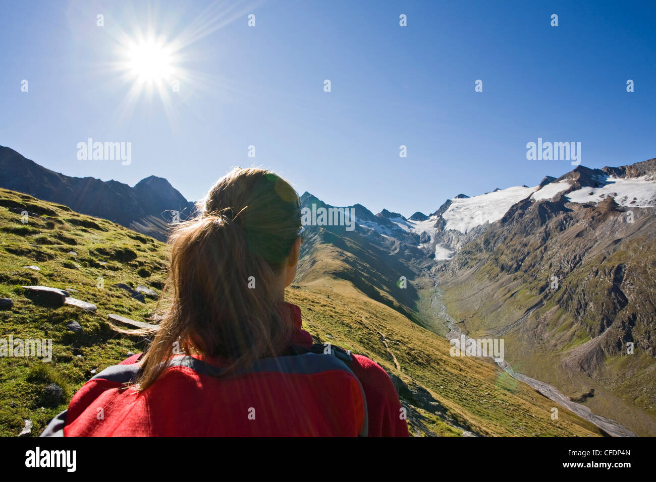 Bella donna mentire indietro nella neve sci da indossare abbigliamento e  occhiali da sole in una giornata di sole in montagna Foto stock - Alamy