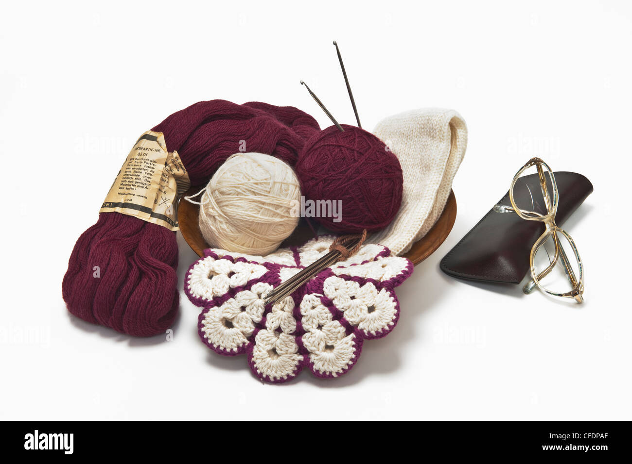 La lana di differenti, un potholder, aghi da maglia e i bicchieri sono vicine le une alle altre Foto Stock
