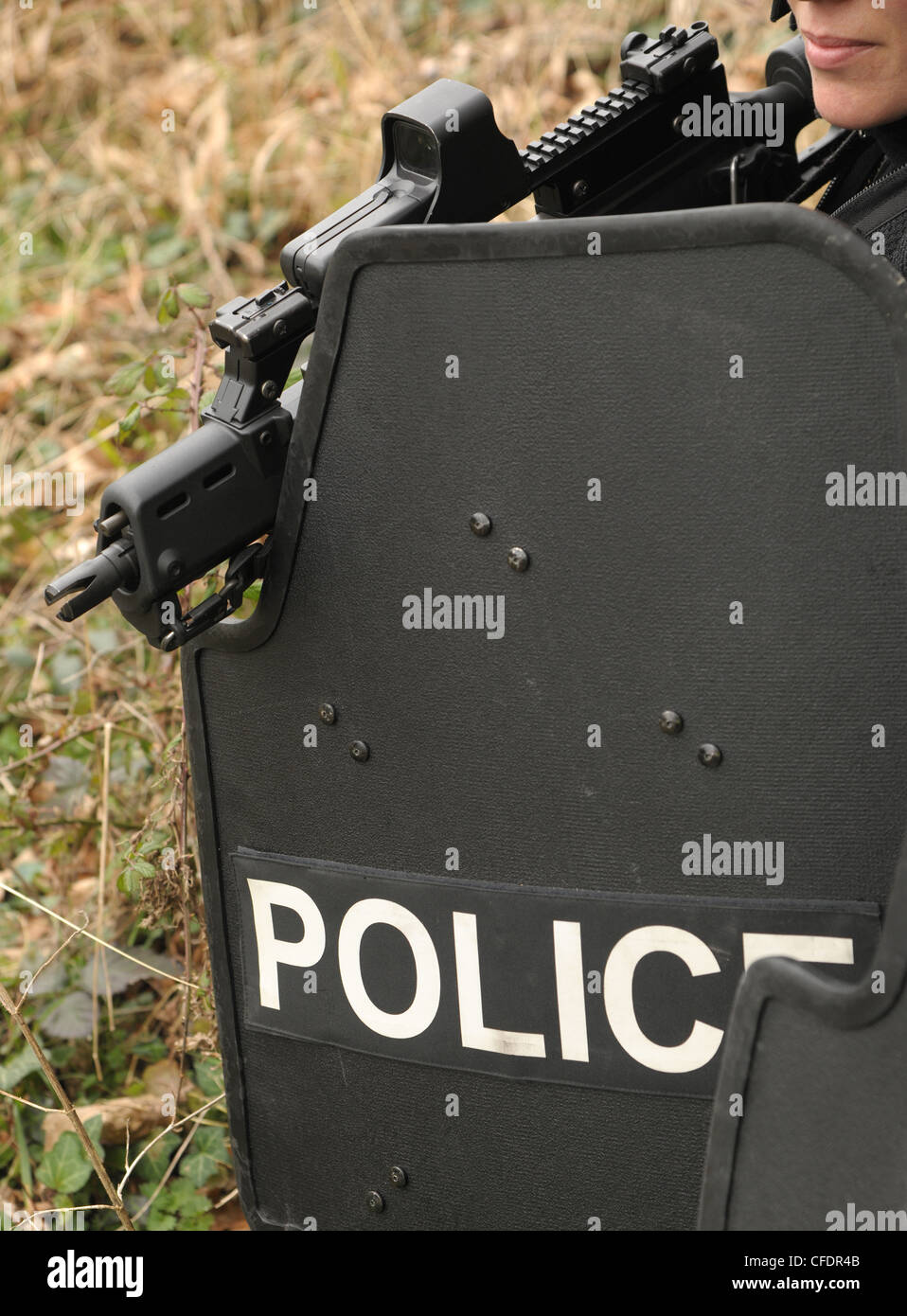 Una femmina di polizia ufficiale di armi da fuoco armati con un Heckler e Koch G36C fucile da assalto osserva un incidente. La polizia reale SWAT. Foto Stock