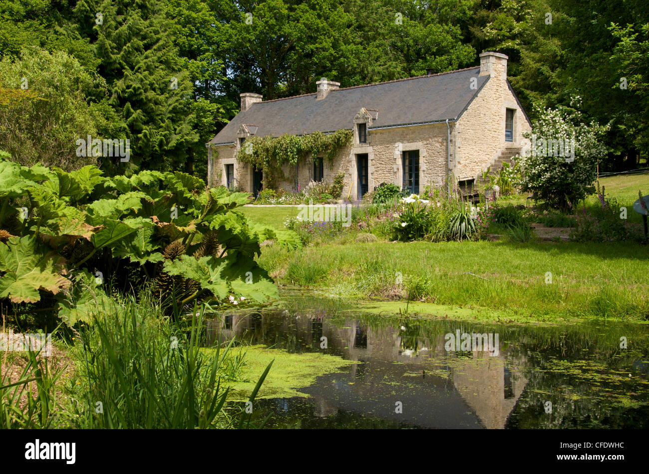 Antica fattoria,stagno, granito pareti e tetto in ardesia, Bubry Village, vicino Hennebont, Morbihan, in Bretagna, in Francia, in Europa Foto Stock