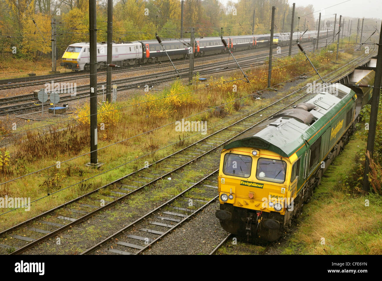 Classe 66 locomotiva diesel 66615 con treno di svuotare i vagoni di carbone e di classe 91 electric loco con treno express al di fuori di York. Foto Stock