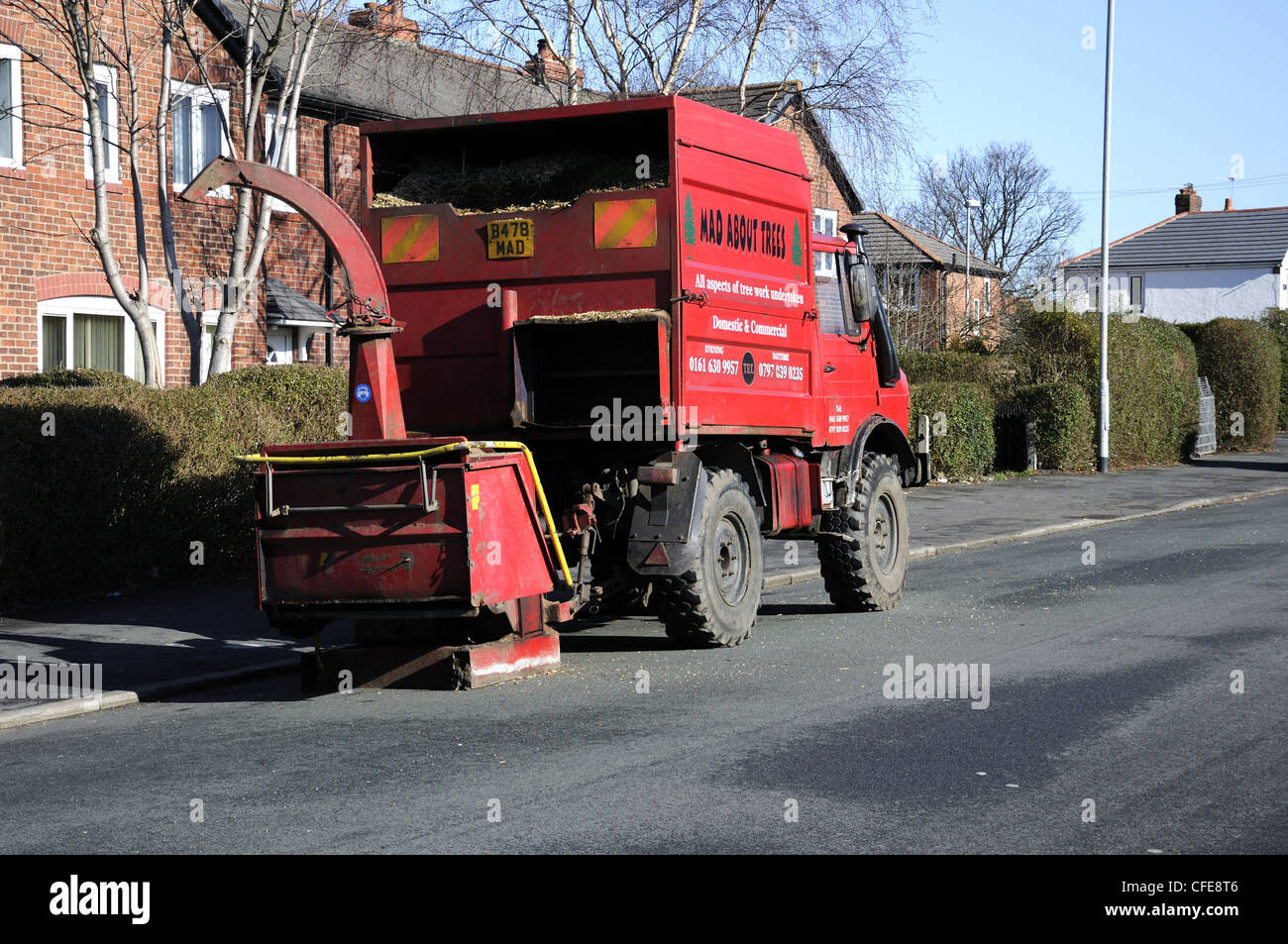 Carro rosso pieno di trucioli di legno con woodchipper Foto Stock