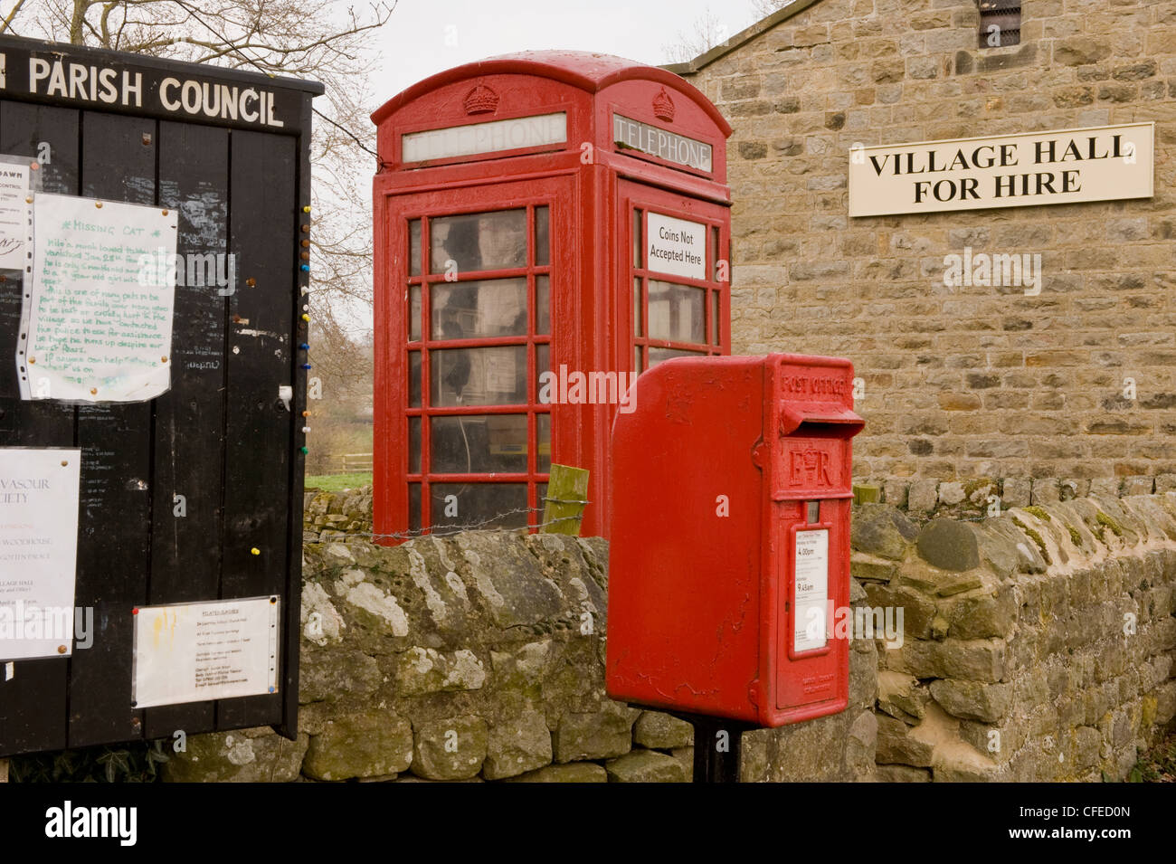 Arredo Urbano - La parrocchia bacheca, rosso post box & iconico K6 nella casella Telefono da village hall (a noleggio segno) - Leathley, North Yorkshire, Inghilterra, Regno Unito Foto Stock