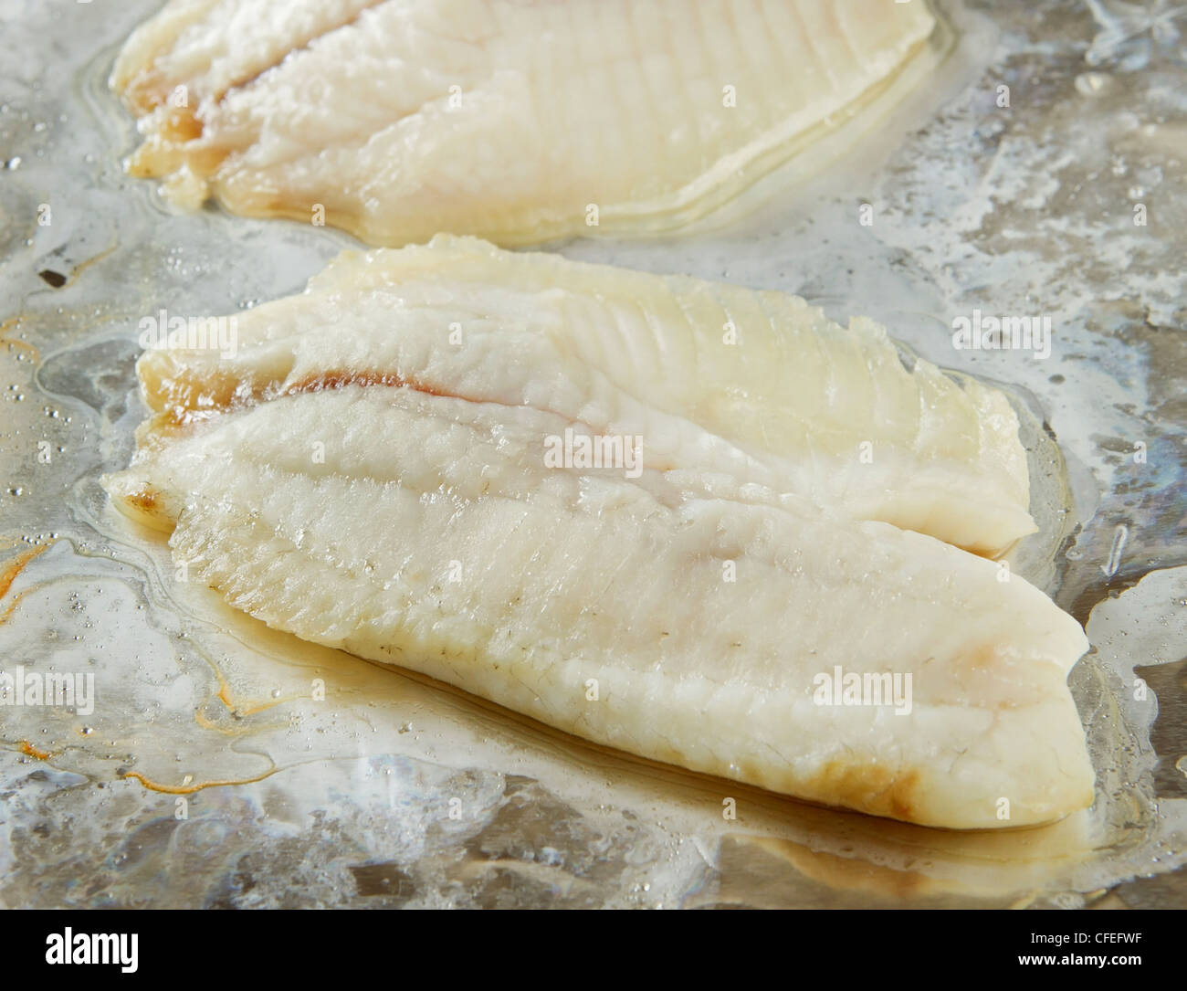 Due pezzi di cotto di pesci di Tilapia sulla lamina Foto Stock