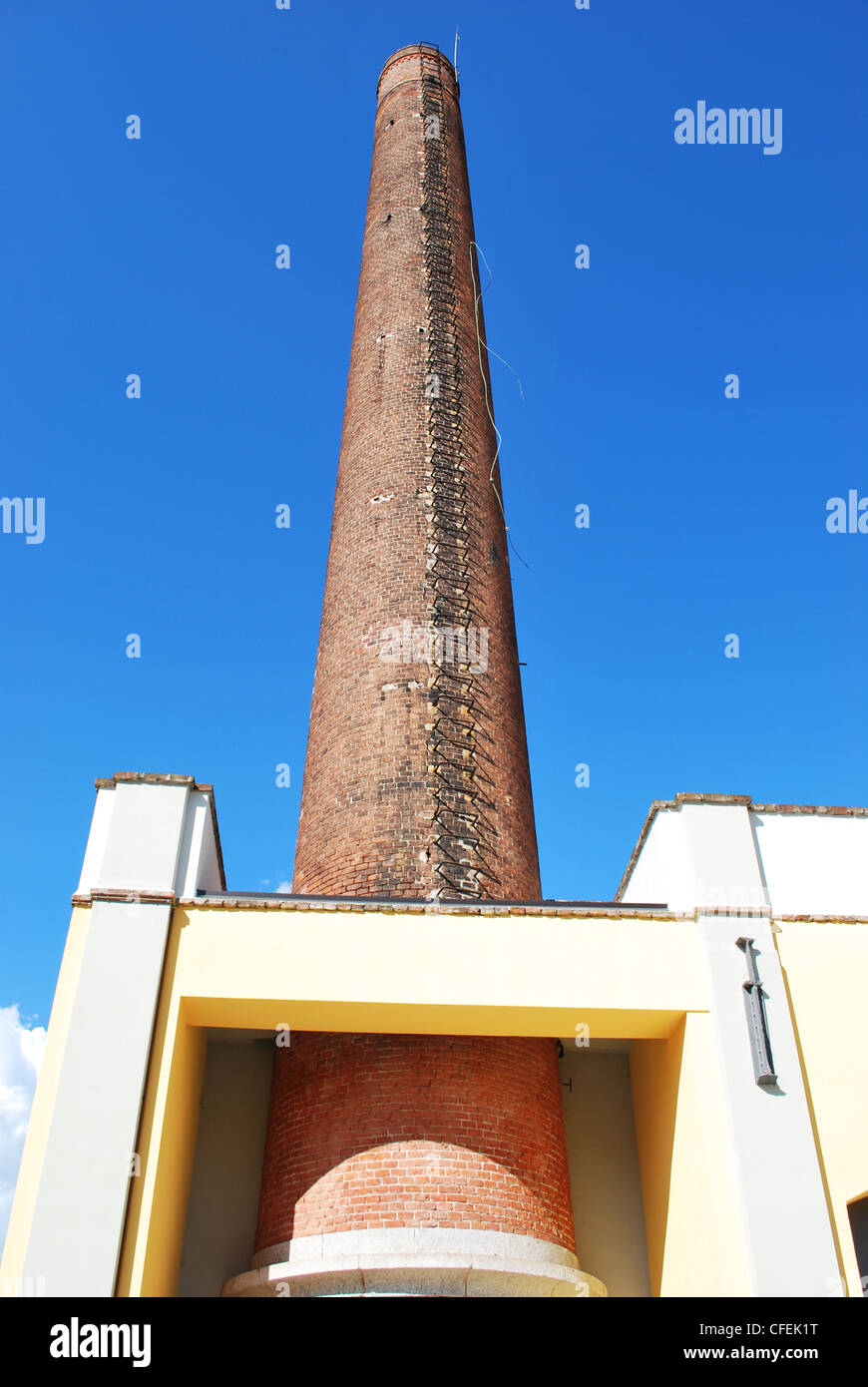 Industriale antico camino in mattoni sul cielo blu Foto Stock