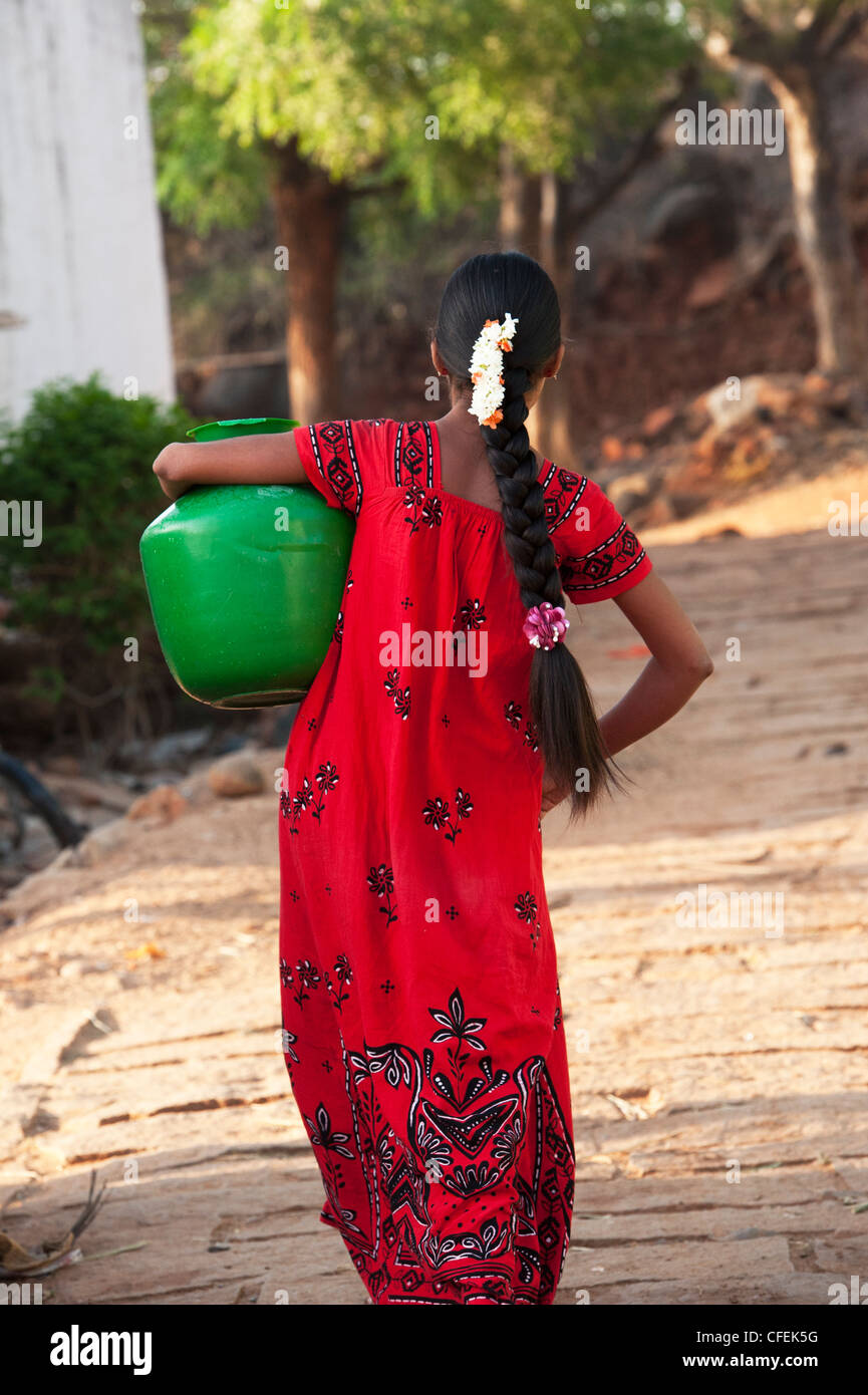 Rurale villaggio indiano ragazza adolescente che porta una pentola di acqua home. Andhra Pradesh, India Foto Stock