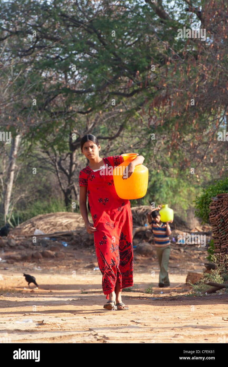 Rurale villaggio indiano ragazza adolescente che porta una pentola di acqua home. Andhra Pradesh, India Foto Stock