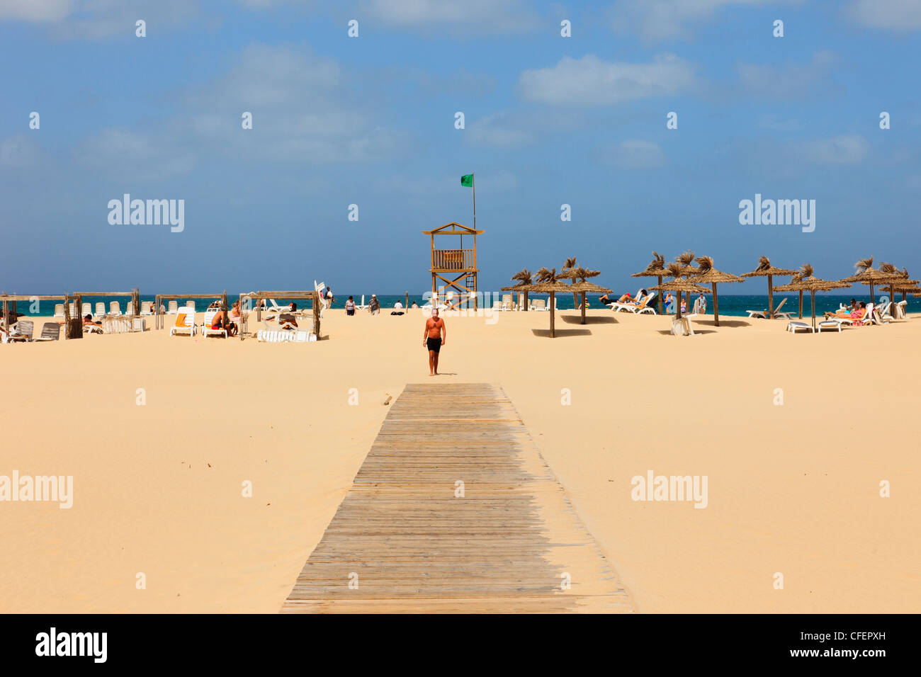 Passerella in legno di fronte spiaggia sabbiosa di vedetta di guardia costiera con la bandiera verde. Praia de Chaves, Rabil, Boa Vista, Isole di Capo Verde Foto Stock