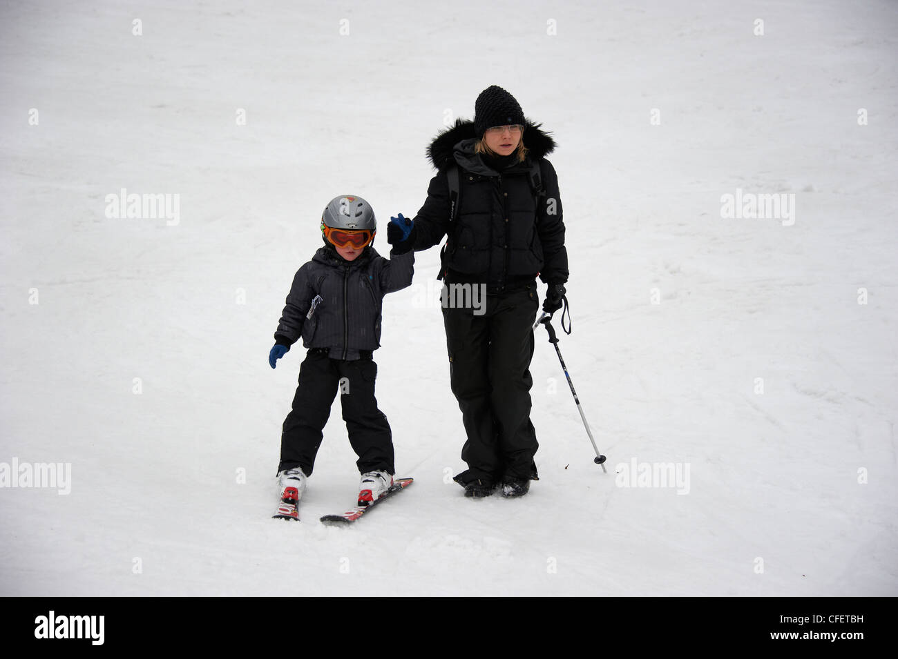 Bambino ragazzo giovane sciare con la madre Foto Stock