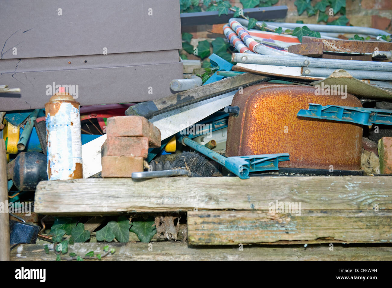 Un vecchio arrugginito tostapane in tra un mucchio di roba in un giardino sul retro. Foto Stock