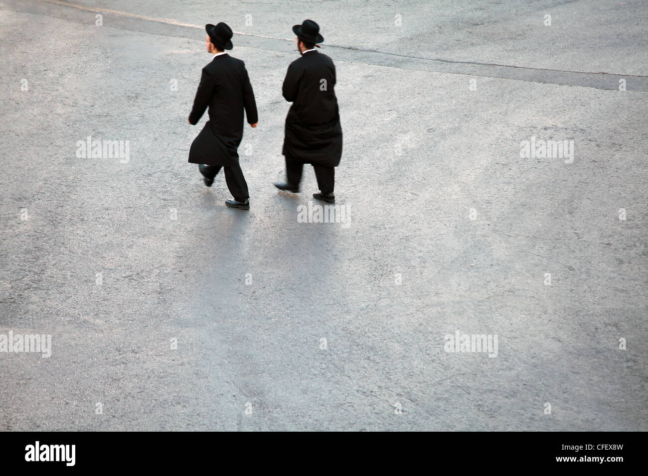 Due uomini Hasidic attraversamento cortile vuoto in rotta verso il Muro del Pianto a Gerusalemme, Israele Foto Stock