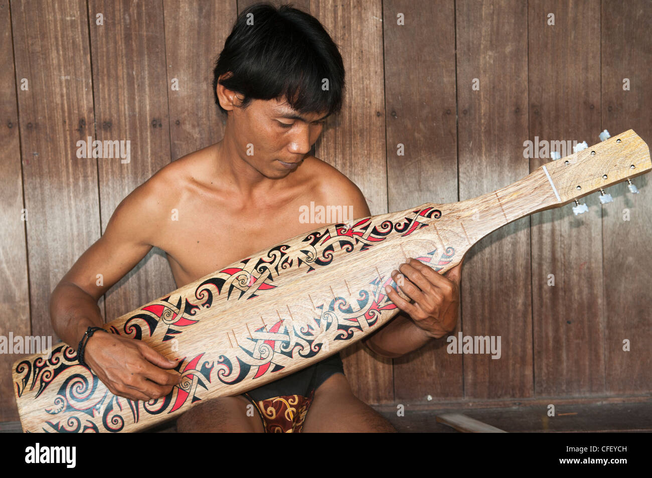 Orang Ulu uomo svolge il suo tradizionale sape nel Sarawak, Borneo Malaysia Foto Stock