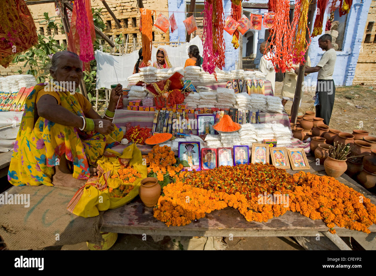 Donna vendita di mala (ghirlande), immagini di divinità Indù e agarbathi (joss bastoni) a Sonepur fiera del bestiame, Bihar, in India Foto Stock