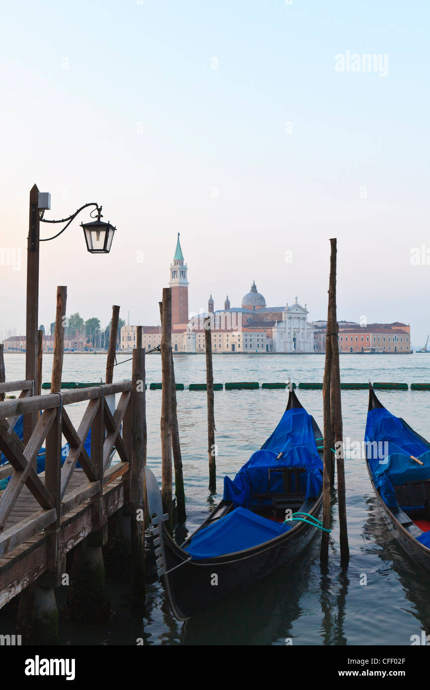 Gondole ormeggiate sulla laguna, San Giorgio Maggiore al di là, Riva degli Schiavoni, Venezia, Veneto, Italia Foto Stock