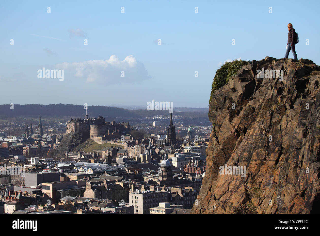 Un turista su Arthur' Seat guardando verso il castello e lo skyline di Auld Reekie, Edimburgo, Scozia, Regno Unito, Europa Foto Stock