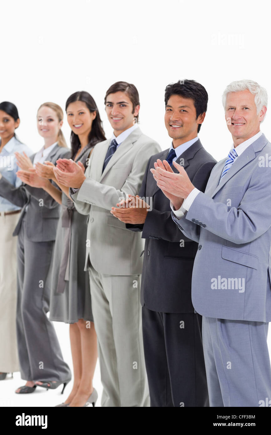 Multiculturale business sorridente la gente applaude e posa Foto Stock