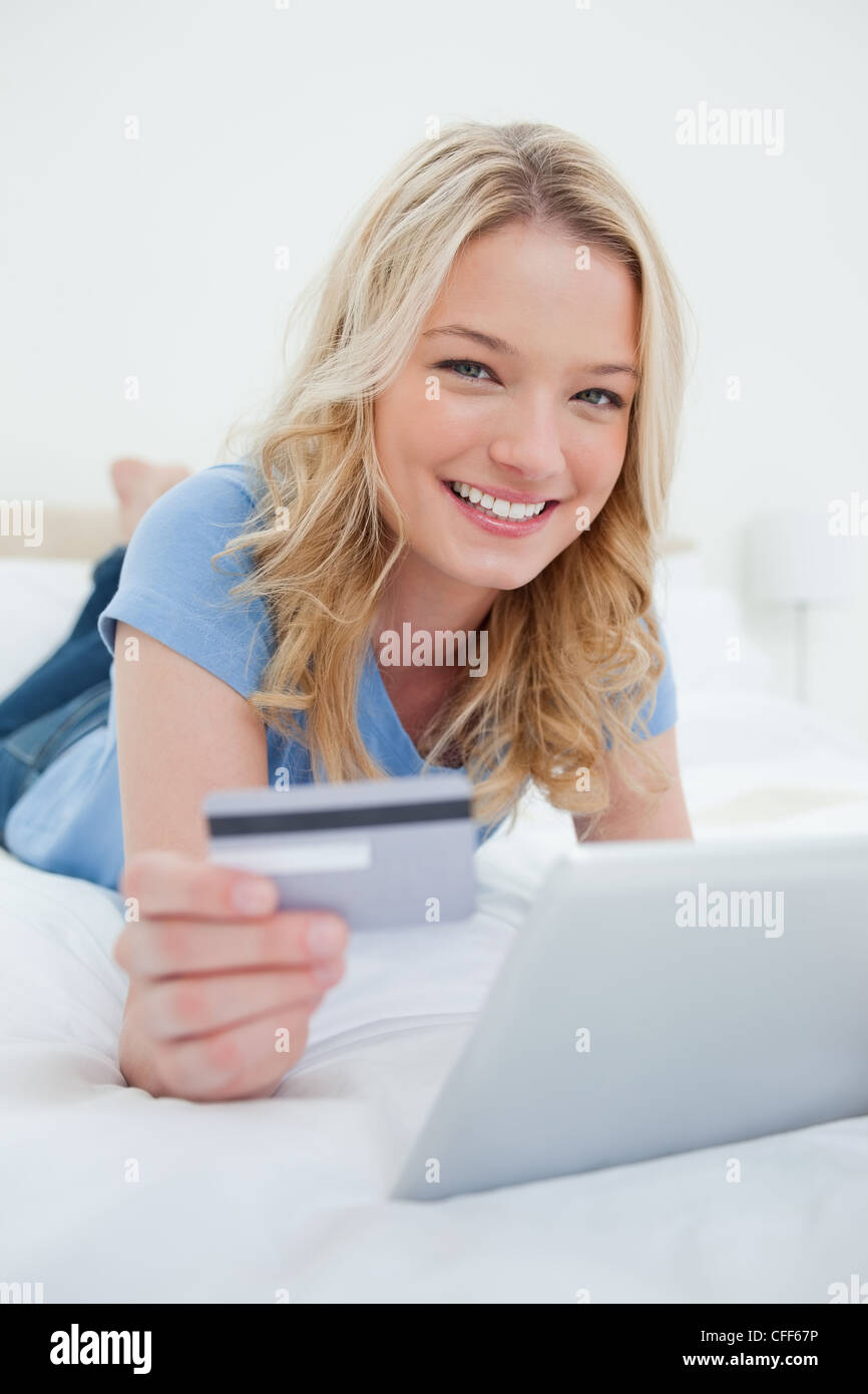 Donna che guarda in avanti con la carta di credito e tablet pc Foto Stock